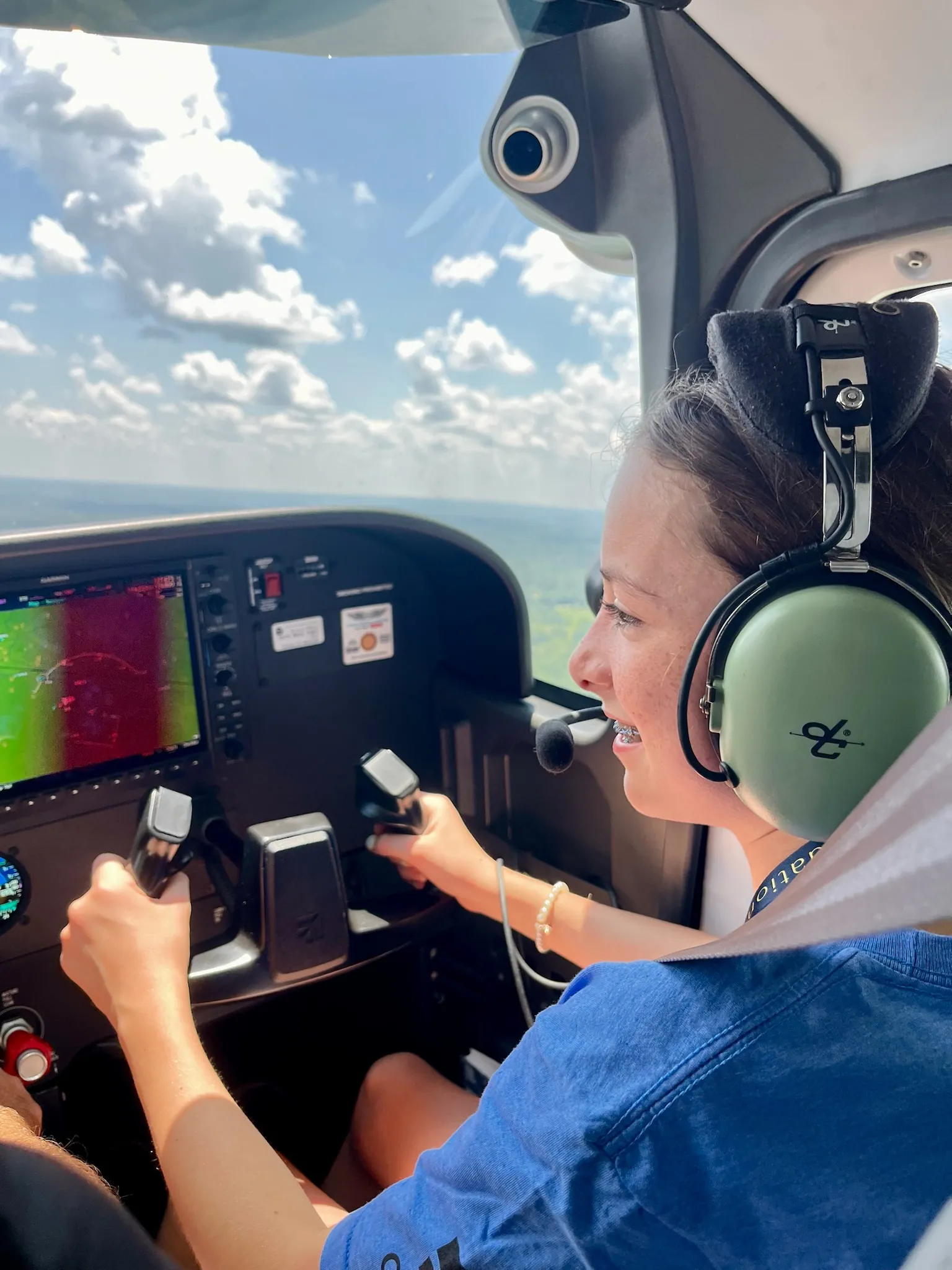 An ACE camper flies the airplane, hands on the controls