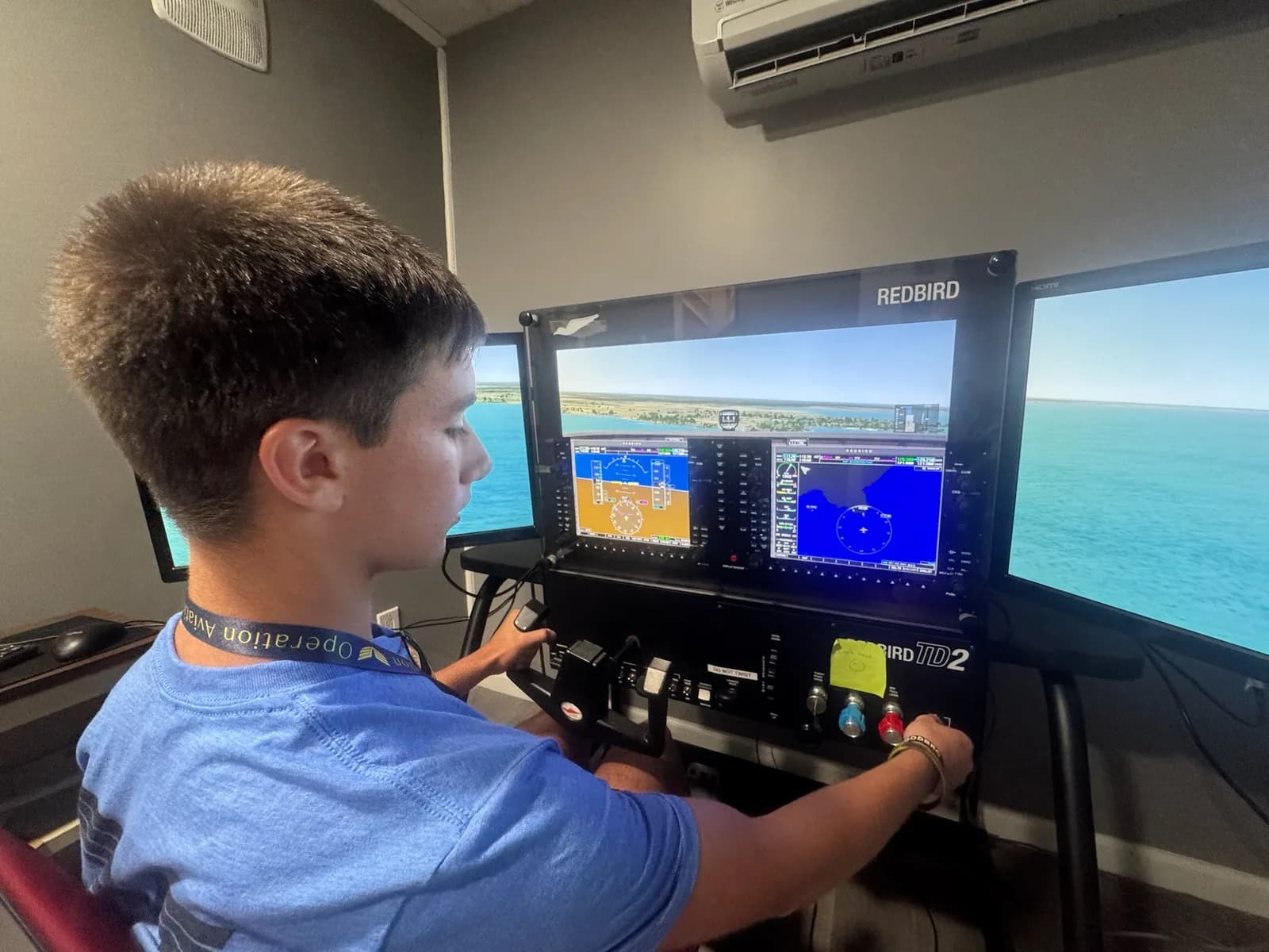 An ACE camper flies the Redbird flight simulator